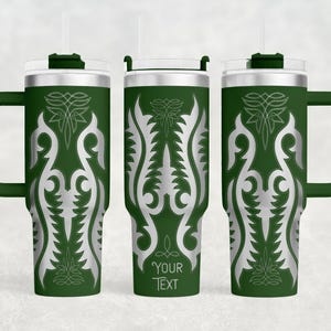 May include: Green travel mug with a silver, stylized floral design. The mug has a handle, a clear lid, and a straw. The text "YOUR TEXT" is printed on the mug. The mug is designed to hold approximately 30 ounces.