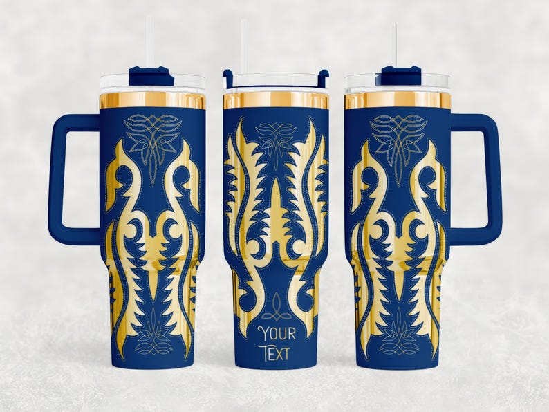 May include: Navy blue insulated tumbler with a gold ornamental design. The tumbler has a handle, a clear lid, and a straw. The design includes the text "YOUR TEXT" at the bottom. The tumbler is designed to hold cold or hot beverages.