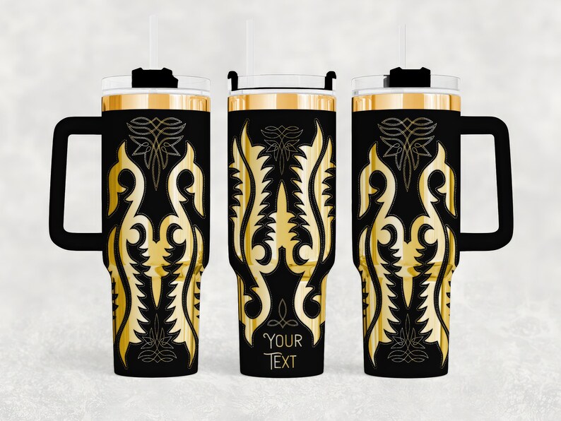 May include: Black and gold insulated tumbler with a handle, straw, and lid. The tumbler features a gold ornamental design on a black background. The design includes a space for custom text. The tumbler is designed to keep beverages cold or hot.