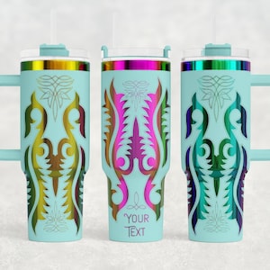 May include: Three light blue insulated tumblers with handles, lids, and straws. Each tumbler features a colorful, ornate design in shades of gold, pink, purple, and green. The middle tumbler has the text "YOUR TEXT" on it.