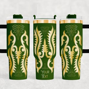 May include: Green travel tumbler with a gold ornamental design and a black handle. The tumbler has a clear lid and a straw. The text "YOUR TEXT" is printed on the tumbler.
