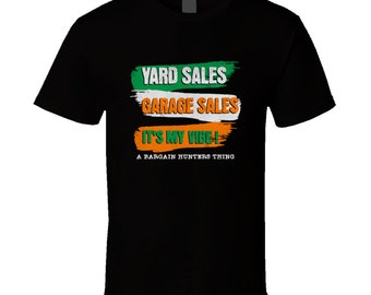 May include: Black t-shirt with green, white, and orange text that reads "Yard Sales Garage Sales It's My Vibe! A Bargain Hunters Thing."