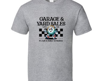 May include: Gray t-shirt with a cartoon clock character running across a checkered finish line. The text reads "Garage & Yard Sales" with the words "Let's Go!" above the clock and "It's Just A Matter Of Priorities" below.