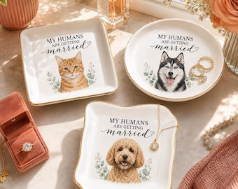 Puede incluir: Tres platos de cerámica blanca con bordes dorados, cada uno con un retrato de mascota y el texto MY HUMANS ARE GETTING married. Un plato cuadrado muestra un gato atigrado naranja, uno redondo un husky y un plato cuadrado un perro doodle.