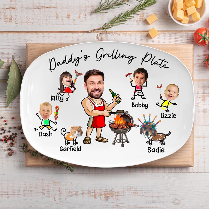 May include: A white oval ceramic serving plate featuring the text Daddy's Grilling Plate. The design includes a central cartoon figure in a red apron grilling, surrounded by illustrated stick figures with photographic faces labeled Kitty, Dash, Garfield, Bobby, Lizzie, and Sadie.