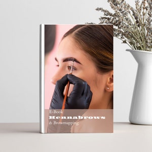 Op de afbeelding: E-book cover met de titel "Hennabrows & Browmapping" in witte tekst op een perzikkleurige achtergrond. Een vrouw met donker haar wordt getoond terwijl ze haar wenkbrauwen laat doen met henna.