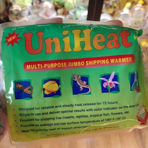 Könnte beinhalten: Grüner und gelber UniHeat Multi-Purpose Jumbo Versandwärmer mit Farb-Indikator. Er ist für eine zuverlässige und gleichmäßige Wärmeabgabe für 72 Stunden ausgelegt. Er bietet eine durchschnittliche wärmere Oberflächentemperatur von 100° F (38° C).