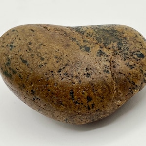 May include: A smooth, heart-shaped stone with a mottled pattern of brown and black. The stone has a polished appearance and a natural, organic aesthetic. The stone is a natural decorative item.