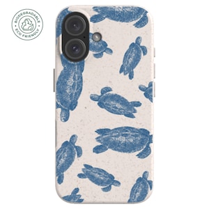 May include: A biodegradable phone case with a cream-colored background and a pattern of blue sea turtles. The case has a dual-lens camera cutout and the words "Biodegradable Eco Friendly" printed on the upper left corner.