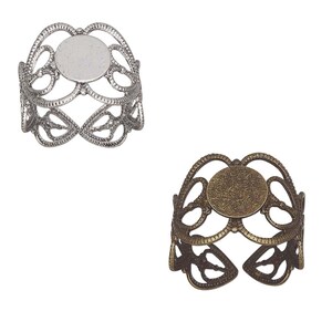 May include: Two silver and bronze filigree rings with a round open space for a cameo or other embellishment.