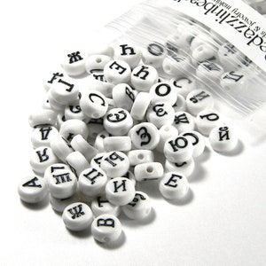 May include: White plastic letter beads with black lettering. The beads are in a clear plastic bag. The beads spell out the letters A, B, C, D, E, F, G, H, I, J, K, L, M, N, O, P, Q, R, S, T, U, V, W, X, Y, Z, 1, 2, 3.