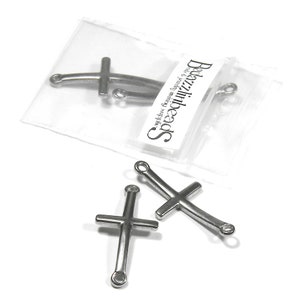 May include: Three silver metal cross charms with jump rings. The charms are in a clear plastic bag with a white label that says "SpeedBeads -  Wholesale Beads & Findings".