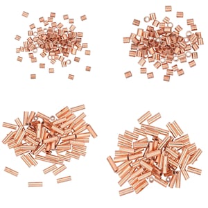 May include: Four groupings of copper crimp beads and tubes. The beads are small, cylindrical, and have a shiny, metallic finish. The tubes are longer and also have a metallic finish. The beads and tubes are scattered against a white background.