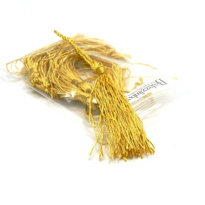 May include: A bag of gold tassel trim. The tassels are made of a soft, silky material and are perfect for adding a touch of elegance to any project.