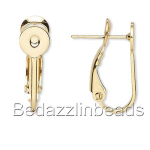 May include: Gold-tone earring clip-on backs. The earring backs have a round, flat top with a small hole in the center. The backs are designed to be used with dangle earrings.