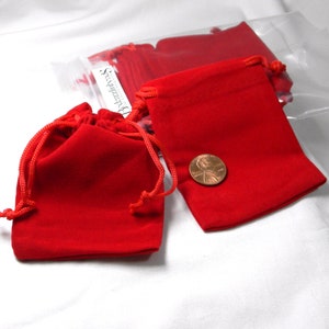 May include: Red velvet drawstring pouches in a clear plastic bag. The pouches are small enough to fit a penny.