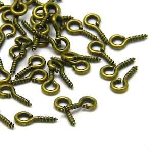 May include: A pile of antique brass screw-in eyelet hooks. These hooks are perfect for adding a touch of vintage charm to your crafts and projects.