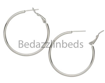 May include: A pair of silver hoop earrings with a hinged clasp.