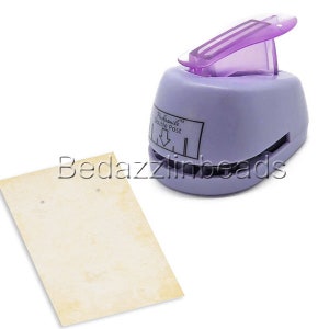 May include: Purple plastic double post earring punch with a white label that says "Remarkable Double Post". A piece of beige card stock with two holes punched in it is shown in the background.