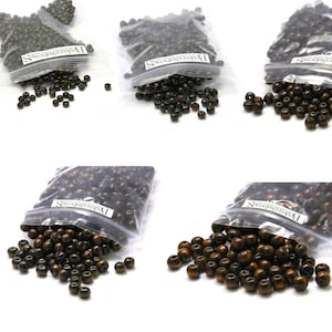 May include: Multiple bags of dark brown wooden beads, some spilled out. The beads are round and appear to be of varying shades of brown. Each bag has a white label with black text. The beads are suitable for jewelry making and crafts.