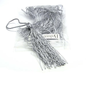 May include: A bag of silver tassel trim, with the text "Beadazz Beads & Jewelry" on the bag.