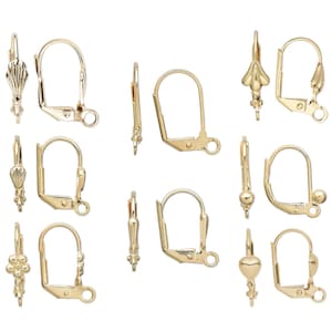 May include: A selection of gold-coloured earring findings, including lever-back and decorative styles. The findings feature various designs, such as floral, shell, and ball accents, and are displayed against a white background. These components are used for jewellery making.