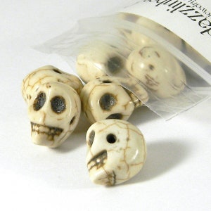 May include: A bag of white skull beads with brown detailing. The beads are made of bone or a bone-like material.