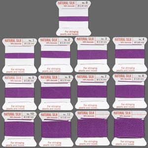 May include: A set of 12 spools of purple natural silk thread for stringing pearls and beads. The spools are labeled with numbers 0 through 12 and the corresponding thread diameter in millimeters.