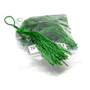 May include: A bag of green silk tassels. The tassels are approximately 2 inches long and are made of a soft, silky material.
