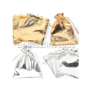 May include: An assortment of metallic gold and silver drawstring pouches. The pouches are in various sizes and shapes, with a shiny, textured finish. The text "Bedazzlinbeads" is visible in the image.