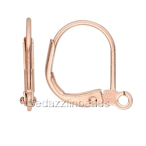 May include: A pair of rose gold earring hooks. The hooks are made of metal and have a smooth finish. They are designed to be used with earrings that have a loop or a jump ring.