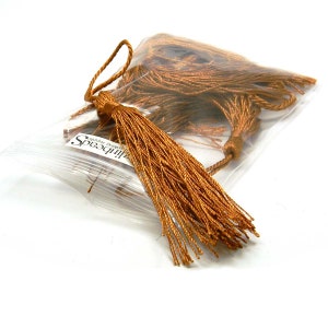 May include: A bag of gold tassel trim with a label that reads "Zilli Beads, making memories".
