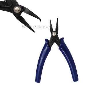 May include: Close-up of two pairs of black and blue pliers. One pair is open, displaying the pointed tips, while the other is partially visible. The handles are a deep blue, and the metal components are black.