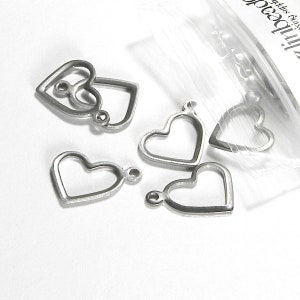 May include: Five silver metal heart-shaped charms with jump rings. The charms are in a clear plastic bag.