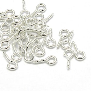 May include: A pile of silver screw-on eyelet hooks. These hooks are great for adding a touch of elegance to your jewelry or crafts.