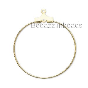 May include: Gold-toned hoop earring findings with a jump ring at the top. The findings are designed to be used for making earrings.