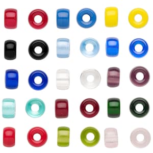 May include: A collection of colorful glass beads in various shapes, including round and cylindrical. The beads are in shades of red, blue, yellow, green, and purple. Some beads have a solid color, while others are translucent or have a striped pattern.