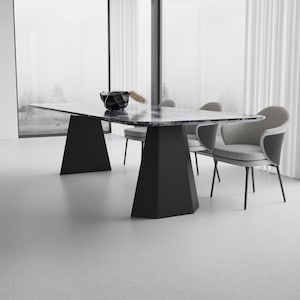 May include: A contemporary dining room set. It features a rectangular marble-topped table with black geometric legs. The table is surrounded by grey upholstered chairs with black metal legs. A black decorative bowl sits on the table. Large windows with white curtains are in the background.