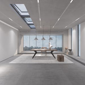 May include: A modern interior space with a large wooden table, a rug, and a bust sculpture. The room has large windows, pendant lights, and a skylight. The color palette is neutral, with shades of gray and brown.