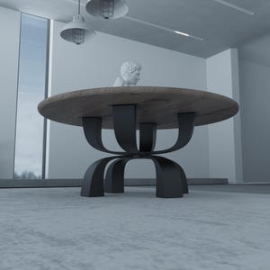 May include: A round wooden table with a black metal base. The base is made of four curved metal pieces that meet in the center. The table is in a modern room with a white wall and a window in the background.