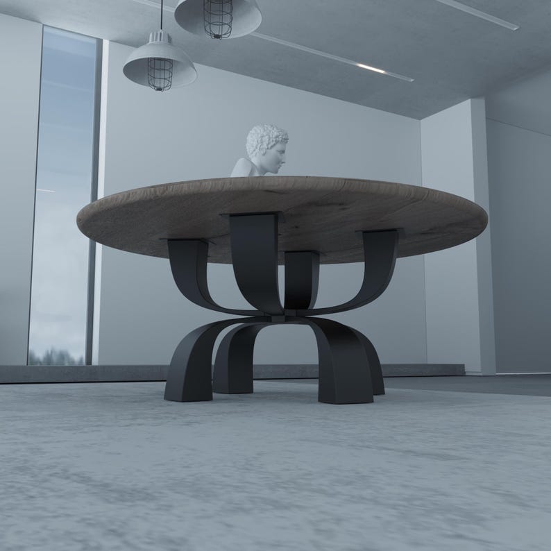 May include: A round wooden table with a black metal base. The base is made of four curved metal pieces that meet in the center. The table is in a modern room with a white wall and a window in the background.