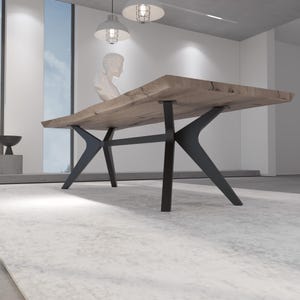 May include: A large, rectangular wooden dining table with a natural edge. The tabletop is supported by black, angular metal legs. The table is set on a light-colored rug in a modern, minimalist interior.