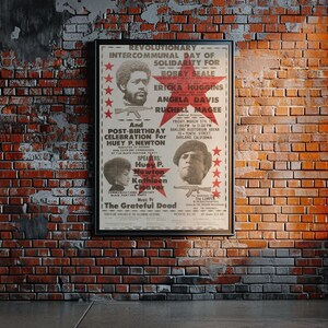 Pode incluir: Um cartaz vintage anunciando um Dia Intercomunal Revolucion&aacute;rio de Solidariedade para Bobby Seale, Ericka Huggins, Angela Davis e Ruchell Magee. O evento tamb&eacute;m &eacute; uma celebra&ccedil;&atilde;o p&oacute;s-anivers&aacute;rio de Huey P. Newton. O cartaz apresenta uma estrela vermelha com uma imagem em preto e branco de Bobby Seale segurando um rifle. O evento ser&aacute; realizado na sexta-feira, 17 de mar&ccedil;o de 1972, &agrave;s 19h00, na 1415 6th Street, em Oakland, Calif&oacute;rnia. O evento est&aacute; sendo organizado por The Grateful Dead.