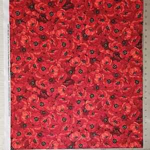 Puede incluir: Tela roja cubierta con un denso patr&oacute;n de flores de amapola. Las amapolas tienen p&eacute;talos rojos y centros negros. La tela es adecuada para diversos proyectos de costura y manualidades.