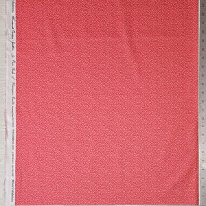 May include: A piece of red fabric with a repeating pattern of small, light red swirls. The fabric has a ruler along the right edge and text along the left edge that reads "MARCUSFabrics About Country Sparklers by Pam Buch of Hemstypu will swing VRITION marcusfabrics.com COPYRIGHT PROTECTED MARCUSFabricss."