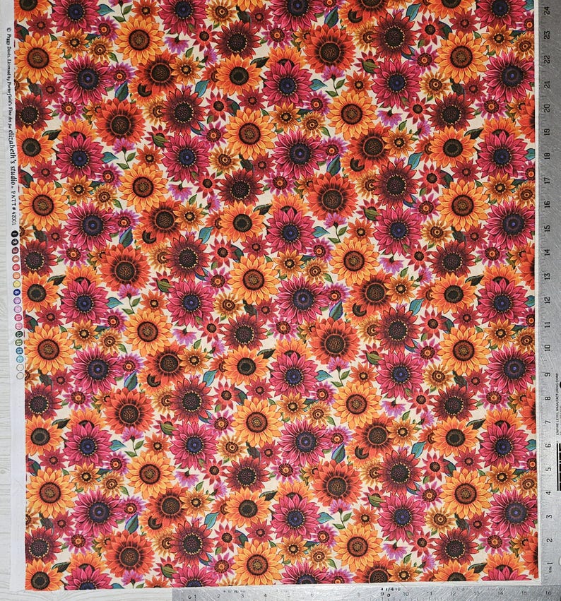 May include: A fabric with a repeating pattern of sunflowers in shades of orange, red, and yellow. The sunflowers are of varying sizes and are set against a cream-colored background. The fabric is printed with the text "elizabeth's studio. PATT 43001".