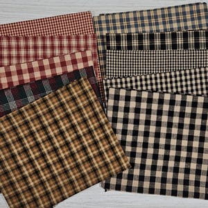 Puede incluir: Una colección de retazos de tela rectangulares con varios patrones de cuadros y vichy en rojo, negro, tostado y crema. Los textiles están superpuestos, mostrando diferentes tamaños de cuadrícula y combinaciones de colores, incluyendo marrón oscuro.