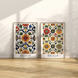 Può includere: Due stampe incorniciate con un motivo floreale colorato e la parola "SICILIA" in basso. Le stampe hanno uno sfondo bianco e sono incorniciate in una cornice di legno chiaro.