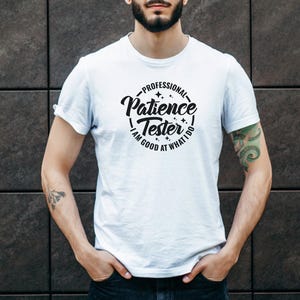 May include: White t-shirt with a black circle graphic that says "Professional Patience Tester - I am good at what I do".