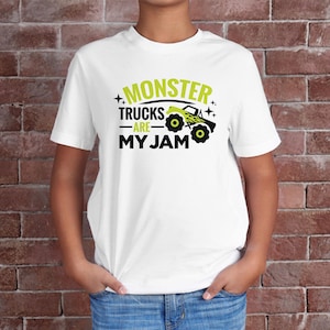 May include: White t-shirt with a green graphic that says "Monster Trucks Are My Jam" and a cartoon monster truck.
